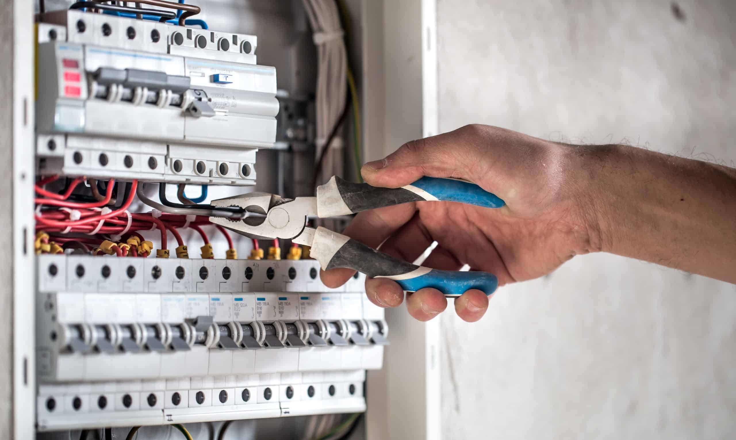 electrical technician working switchboard with fuses 1